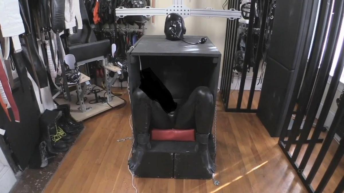 Teased in a Box - J and Elise Graves - Rubber-clad Elise Locks and Teases her Rubber Gimp in a Bonda Teased in a Box - J and Elise Graves - Rubber-clad Elise Locks and Teases her Rubber Gimp in a Bondage Box - Bound Orgasm - Teasing - Rubber - Bondage<br>Wearing a rubber playsuit, Elise is feeling playful! Guiding her rubber gimp into a new piece of bondage gear - an open front wooden box - Elise begins locking his cuffed wrist and ankle chains to the box.  Even before Elise slides the head-trapping wooden neck piece, the rubber gimp is trapped.  With his neck secured, however, his head is fair game for play.  Wearing an enclosed rubber hood, complete with a mouth-filling gag and nostril tubes, the rubber gimp is at the mercy of Elise.  Curious as to whether her whole hand can fit in her gimp's mouth, Elise begins to stretch it open first with her hand and later with an inflatable gag.  Meanwhile, Elise attaches a hitachi to a receiving cup that connects to the gimp's cock.  After flipping the vibrator on, the rubber gimp now needs to pay attention not only to his breathing but also his dick.  Elise has much fun playing with teasing her gimp's level of arousal while strategically pinching off his access to air.  Oh to be a rubber gimp locked in a box with Elise controlling both air and orgasm!  
