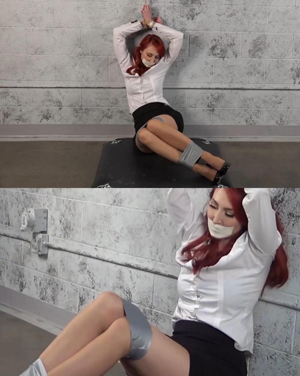 KENDRA JAMES: TIED AND TAPED 肯德拉·詹姆斯 (Kendra James) 浑身上下都被胶带缠住了，装扮成秘书，双手绑在头上，双腿被胶带绑住，嘴巴被微泡沫胶带堵住。Kendra James is all taped up, dressed as a secretary with her hands tied over her head, elgs bound in duct tape and gagged with microfoam tape.