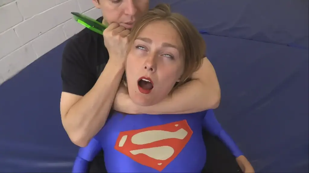 SUPER-VIKA’S DOWNFALL The beautiful SUPERGIRL (played by Vika) has been trapped with kryptonite by a new evildoer known simply as “Sleeperkid”, and he’s recorded a special message for the people of Metropolis:  apparently, he’s the new “big bad” in town, and he’s more than happy to torture the lovely Vika in order to prove it!   He destroys the gorgeous blonde heroine (who had no idea what real PAIN was before this day), using a myriad of holds and finishers to turn her into a submissive cautionary tale to any and all would-be superheroines!